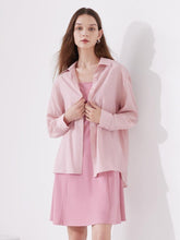 A lady wears a pink shirt and a dress.